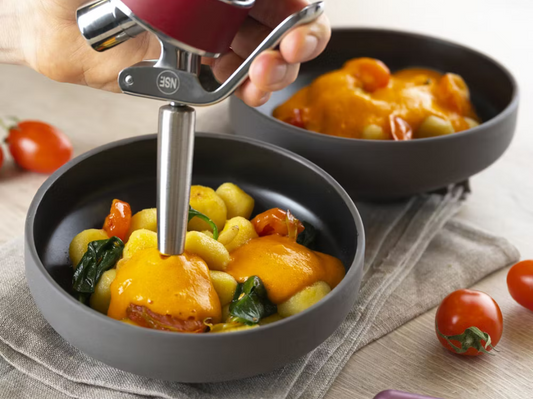 Gnocchi mit gebratenem Gemüse, verfeinert mit einer warmen, luftigen Sauce aus dem iSi Gourmet Whip – frisch angerichtet in einer schwarzen Servierschale.