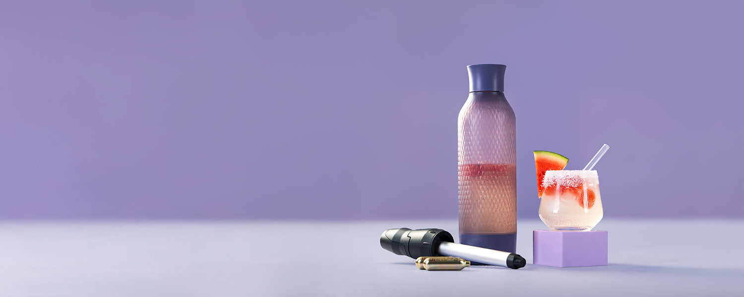 Sparkling Cocomelon mit Eis, Salzrand und Strohhalm – zubereitet mit dem lila iSi Twist’n Sparkle Virtuoso, stilvoll präsentiert auf lila Hintergrund.