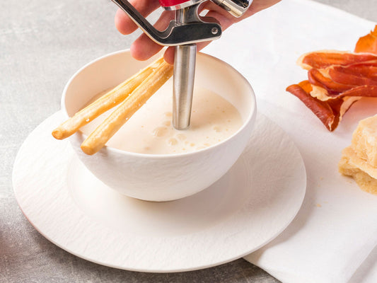 Feine herzhafte Espuma aus dem iSi Gourmet Whip in einer Schale, serviert mit Grissini, Parmaschinken und Brot als Vorspeise.