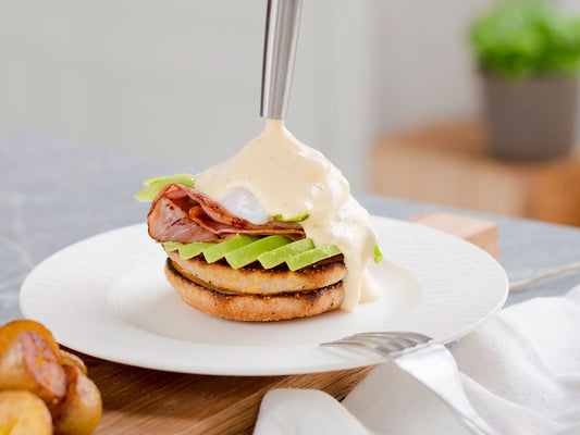 Englischer Muffin mit Avocado, Schinken und pochiertem Ei, verfeinert mit frisch aufgeschäumter Sauce Hollandaise aus dem iSi Gourmet Whip.