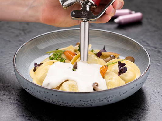 Gefüllte Pasta mit Gemüse und Pilzen, verfeinert mit einer cremigen Sauce aus dem iSi Gourmet Whip – frisch serviert in einer Keramikschale.